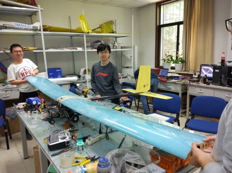 Liming Zheng and teammates with the Air Cargo Challenge aircraft in the laboratory
