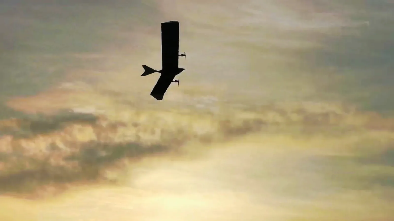 A fixed-wing aircraft soaring at sunset